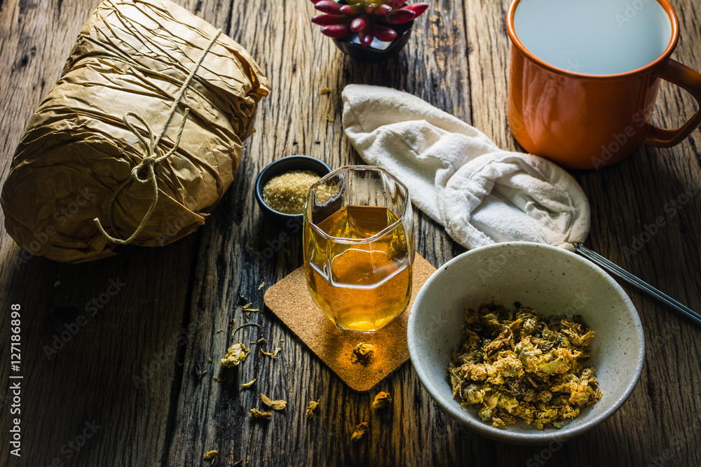 Focus Spot Chrysanthemum Tea and dried chrysanthemum on an old wooden table. Chrysanthemum blossoms are a type of herbal plants. In the morning, drink chrysanthemum Tea will make you feel refreshed. Focus Spot Chrysanthemum Tea and dried chrysanthemum on an old wooden table. Chrysanthemum blossoms are a type of herbal plants. In the morning, drink chrysanthemum Tea will make you feel refreshed.
