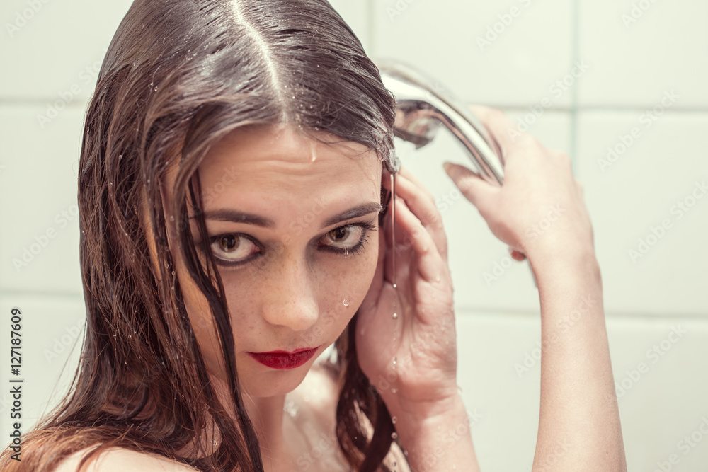 Naklejka premium Close-up portrait of a wet sad woman under washer