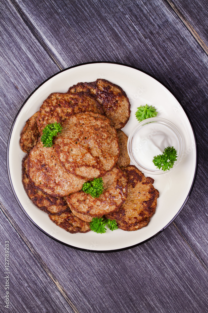 Liver Patties with Sour Cream and Parsley. Liver Cakes or Fritters of Liver. Healthy snack or take-away lunch bites. View from above, top studio shot