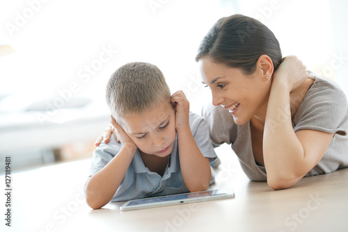 Mommy with little boy playing with digital tablet
