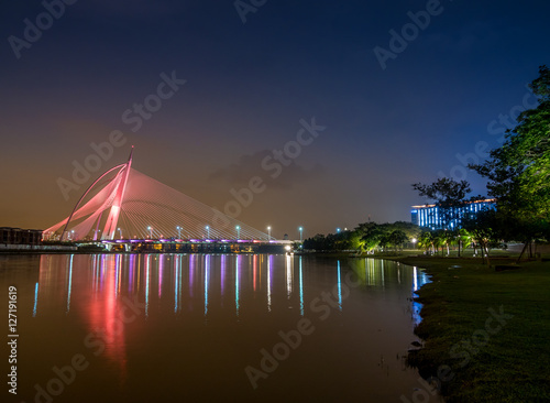 Orange colour lighted Seri Wawasan Bridge with reflection on the water at Putrajaya  Malaysia