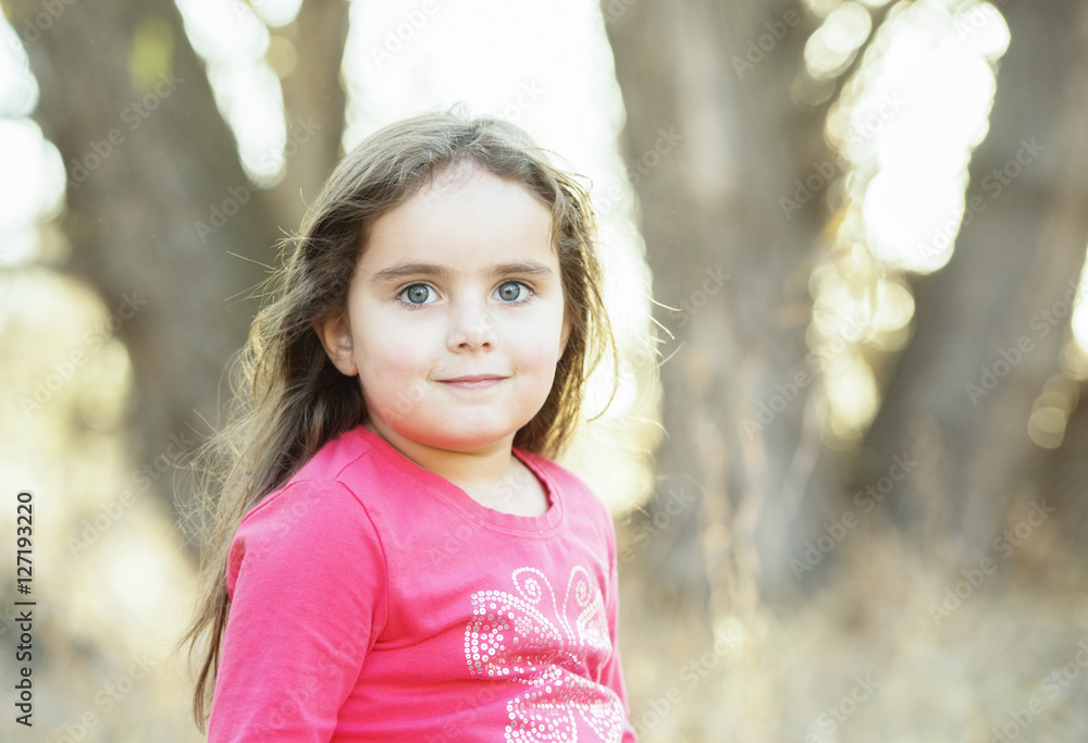 Little Girl with Long Hair Playing Outside in a Natural Environment Little Girl with Long Hair Playing Outside in a Natural Environment