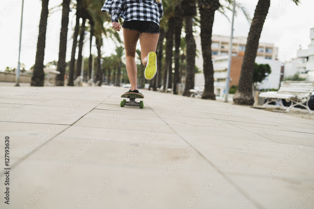 Back view of young woman skateboarding Back view of young woman skateboarding
