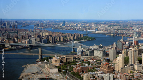 An aerial cityscape view of New York City with East River and Brooklyn, Manhattan, Williamsburg and Queensboro bridges visible.