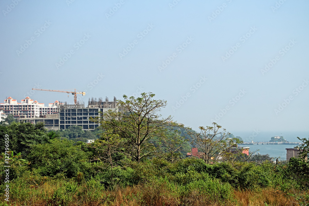Construction of high-rise apartment buildings on a hillock with scenic sea view