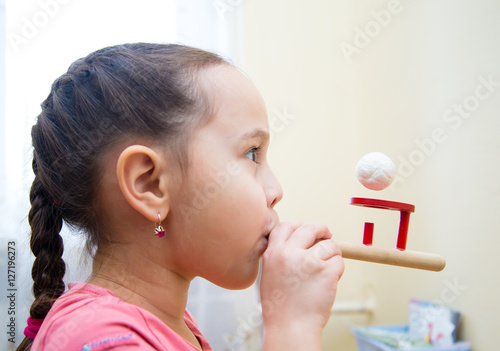 Little girl in class with a speech therapist . The use of special tools for speech correction.
