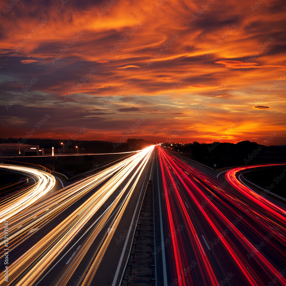 Obraz premium Speed Traffic at Sundown Time - light trails on motorway highway