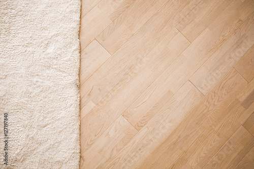 Laminate parquete floor with beige soft carpet