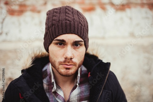 Portrait of attractive guy with wool hat in a old house.