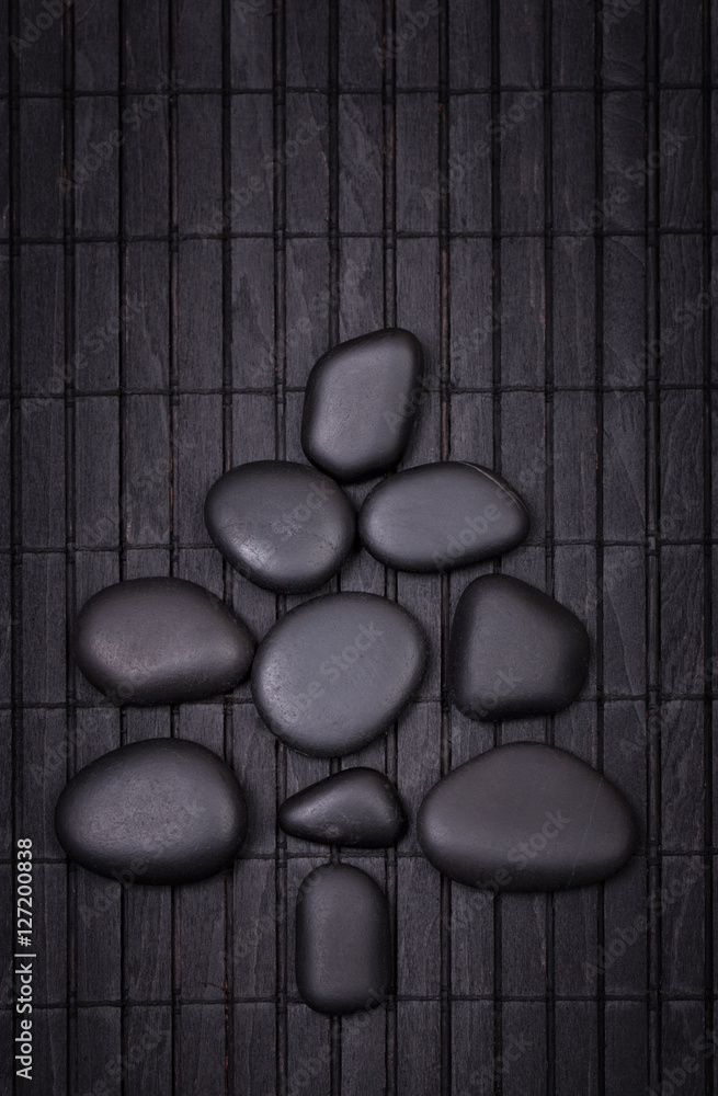 Black zen stones in a shape of christmas tree on a wooden black