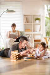 Cheerful family at home, Daddy playing with his daughter
