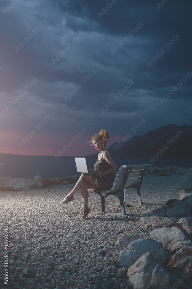 pretty woman with computer on beach