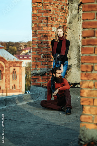 Young couple near roof brick wall