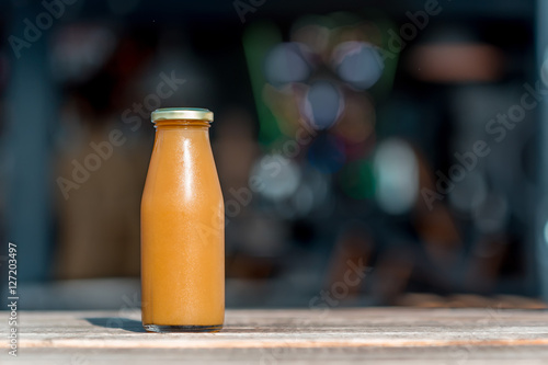 Raw peach juice in glass bottle