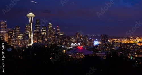 Seattle, Washington, USA - illuminated skyline of Seattle with Space needle, harbor and Elliott Bay - view from Kerry Park at sunset with clouds - Timelapse with motion and zoom out 