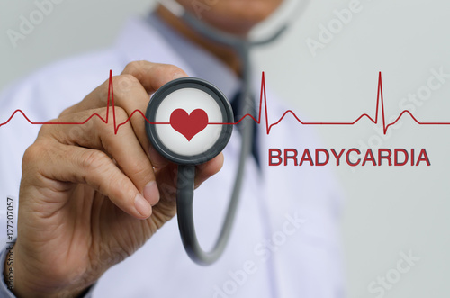 Doctor holding stethoscope and EKG graph photo