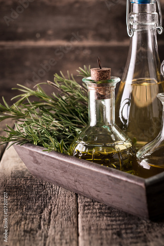 Assortment of spicy sunflower corn sesame seeds  avocado  grape seeds oils with herbs and spices in different bottles on wooden background