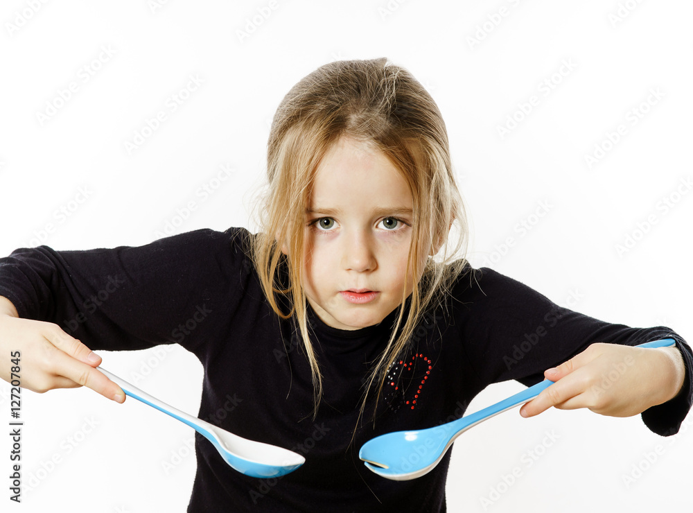 Preschooler girl playing with spoons for salad Preschooler girl playing with spoons for salad