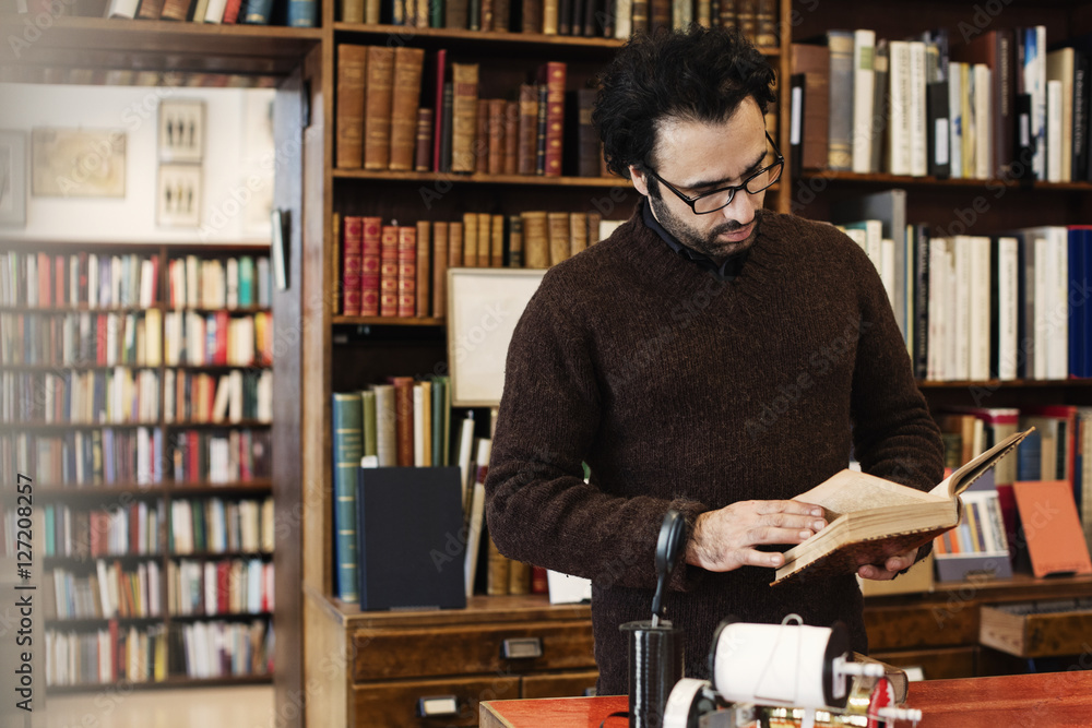 Owner reading book while standing in store Owner reading book while standing in store