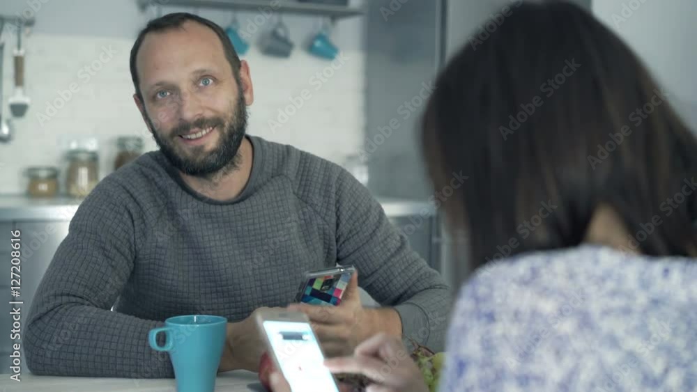 Young couple using smartphones by table in kitchen at home, portrait of happy man
Young couple using smartphones by table in kitchen at home, portrait of happy man