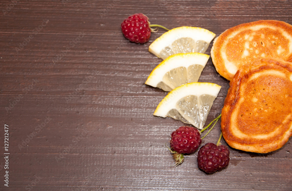 pancakes with raspberry on wooden background.