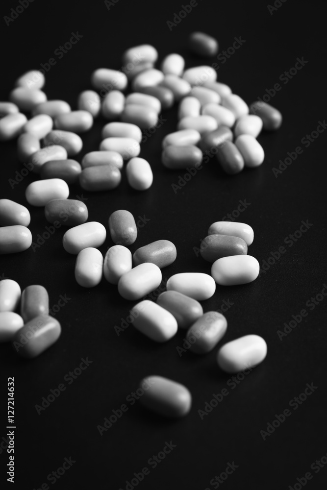 White Pills (Tablets) on Glossy Black Background