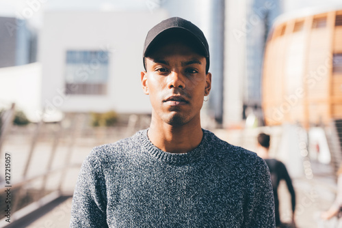 Young handsome american african man outdoor in the city, looking at camera, serious - swag, resolved, resolute concept photo