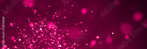 glitter banner: festive star-shaped glitter in shades of pink with bokeh effect in front of a dark background