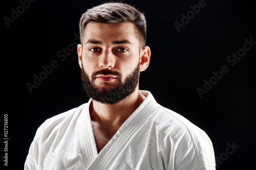 The portrait of the guy with the beard in a kimono against a black background