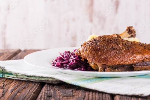 Portion of duck breast with cabbage and crispy skin on white plate