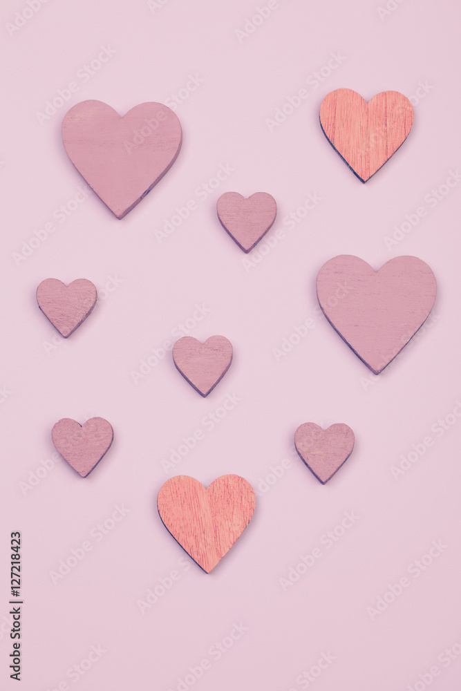 Flat lay. Different sizes and colors valentines hearts on a pink surface