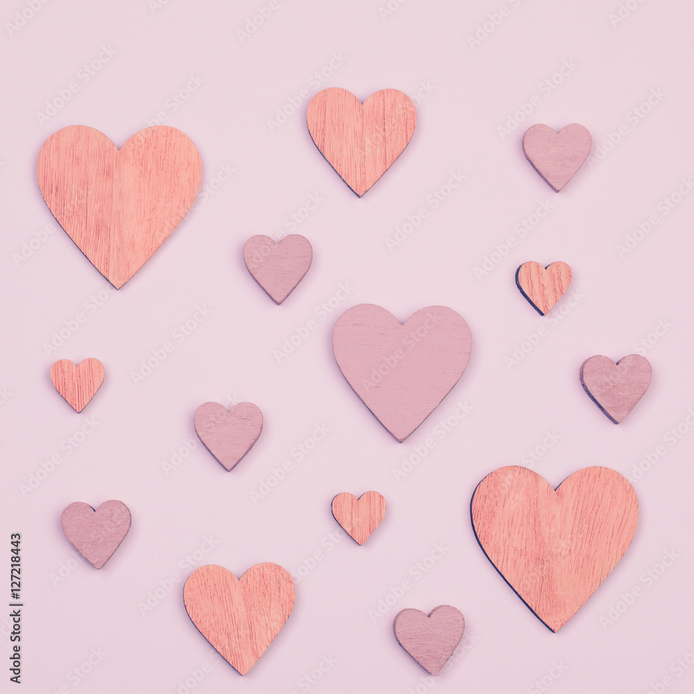Flat lay. Different sizes and colors valentines hearts on a pink surface