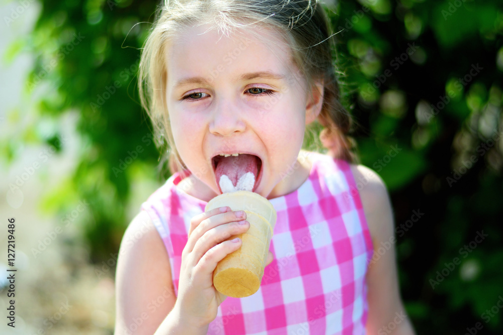 Adorable little girl eating ice cream on summer day Adorable little girl eating ice cream on summer day