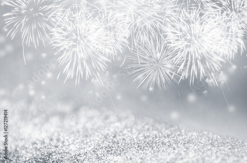 Defocused silver and gray fireworks and bokeh on gliter paper at New Year and copy space. Abstract background holiday.