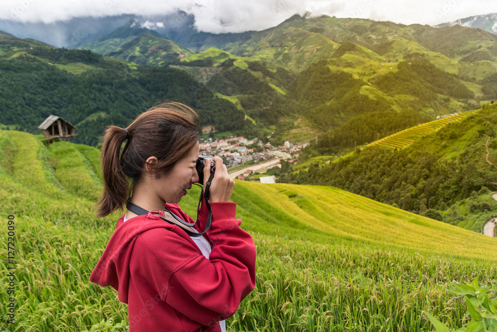 female adventure traveler taking a photo at the nice view of Mu Cang Chai, Vietnam. female adventure traveler taking a photo at the nice view of Mu Cang Chai, Vietnam.