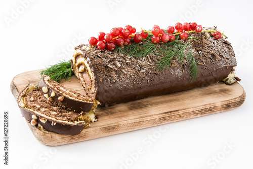 Фотография Chocolate yule log christmas cake with red currant isolated on white background