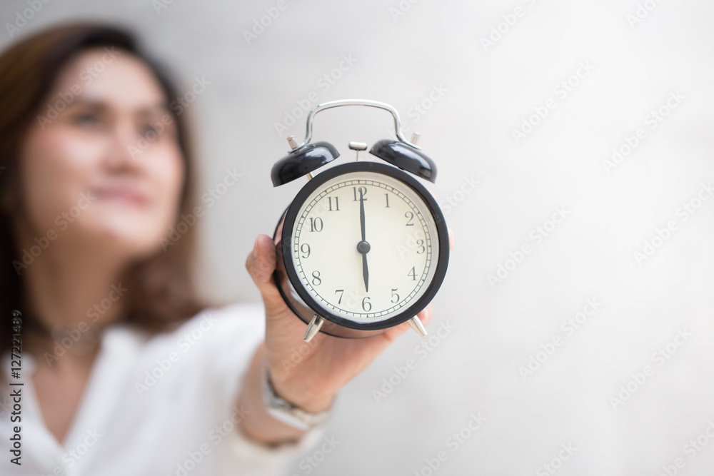 Asian women hand retro clock times at 6 o'clock, It's time to do something concept. Asian women hand retro clock times at 6 o'clock, It's time to do something concept.