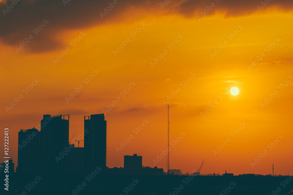golden orange dusk sky with silhouette city metro urban building vintage color tone for postcard background.