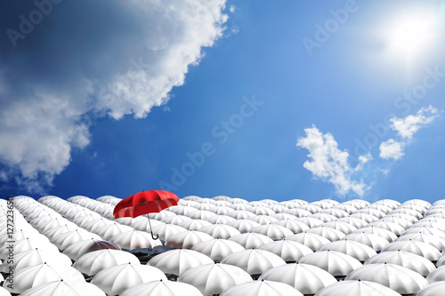 3D Rendering : illustration of Red umbrella floating above from the crowd of many white umbrellas against blue sky and clouds.Business leader concept, being different concepts