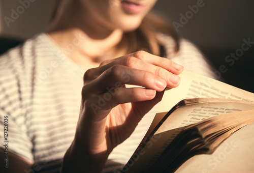 Close up on woman hands turning page in vintage book. Woman read a book.