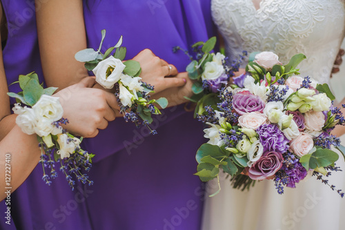 Fototapete Close up of floral compositions worn around wrists of bridesmaids matching perfectly to bridal bouquet of flowers