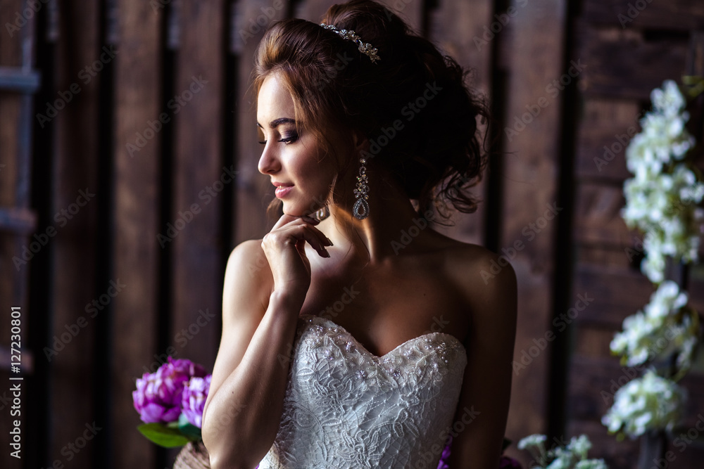Gorgeous bride young woman in a wedding dress with perfect makeup and hairstyle