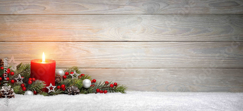 Weihnachten oder Advent Hintergrund: Holz, eine Kerze und Tannenzweige auf Schnee, Panorama Format mit Textfreiraum