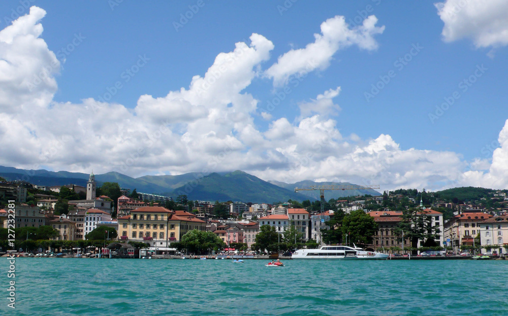 Lago Maggiore and the hills of the Ticino with a small idyllic village and a ship in the foreground