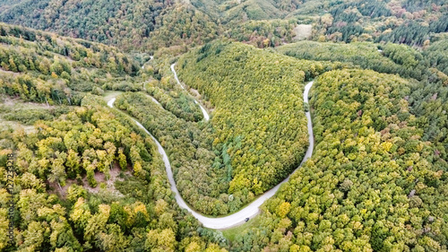 Fototapeta Naklejka Na Ścianę i Meble -  Curvy road in green forest, low hills. Slovakia. Autumn nature.