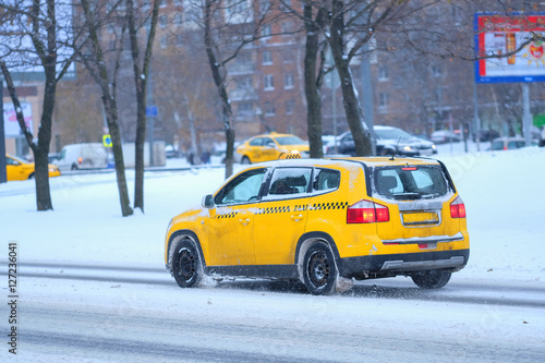 Moscow, Russia - November, 12, 2016: Taxi on a snow-covered road after high snow-storm in Moscow, Russia