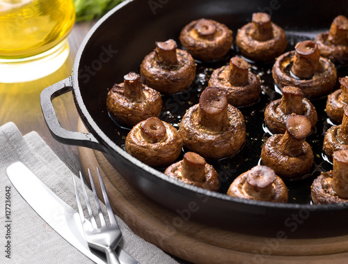 Homemade baked mushrooms in the pan on a cutting board.