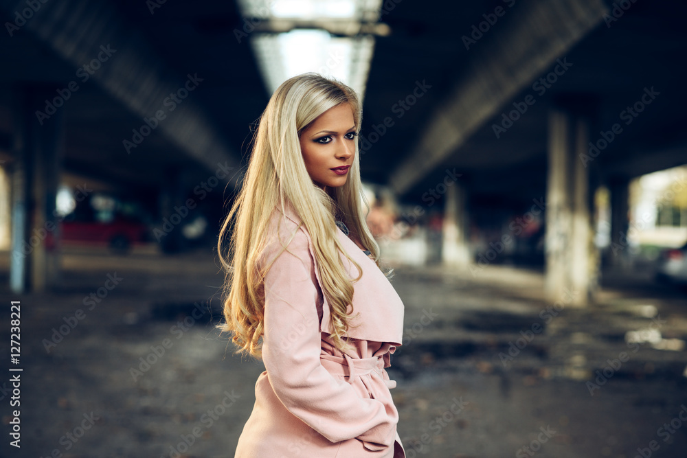 Portrait of the beautiful blonde in a pink coat