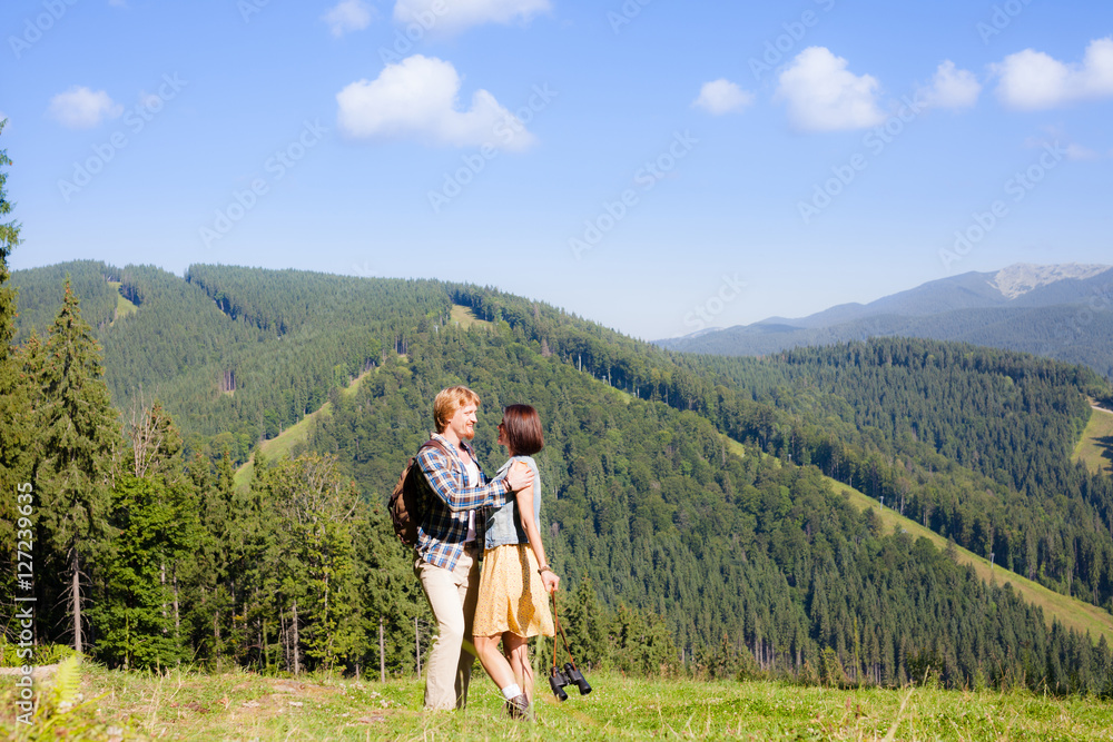 Fototapeta premium Happy beautiful couple on the green grass meadow