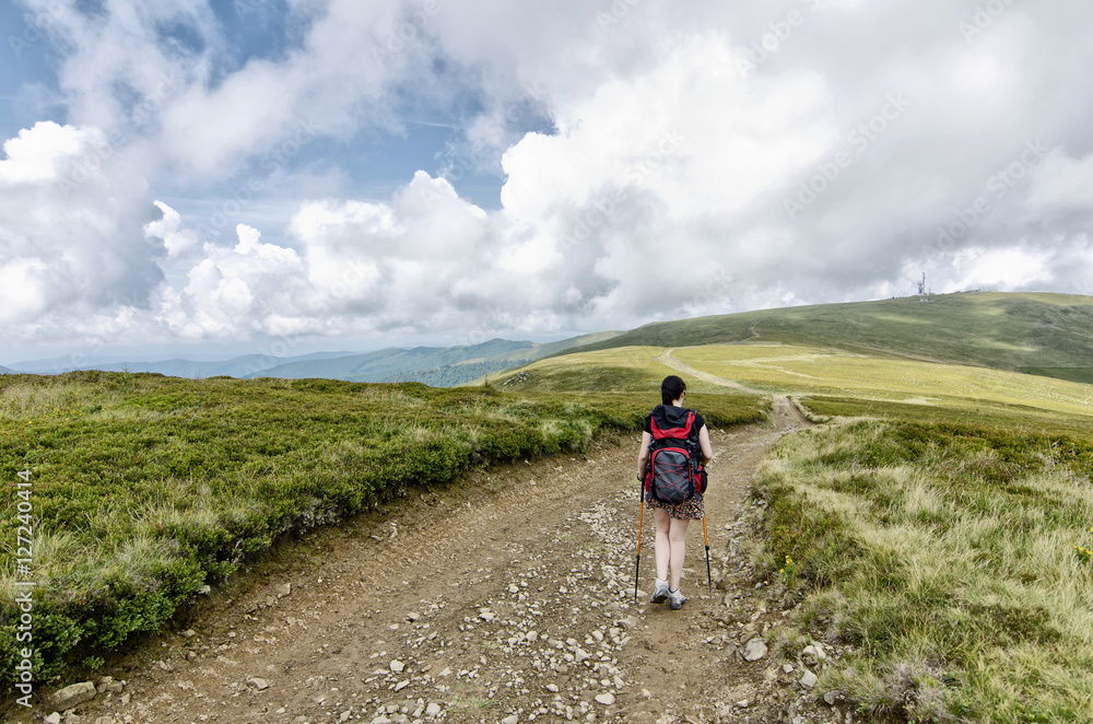 Girl walking down the road in the mountains Girl walking down the road in the mountains